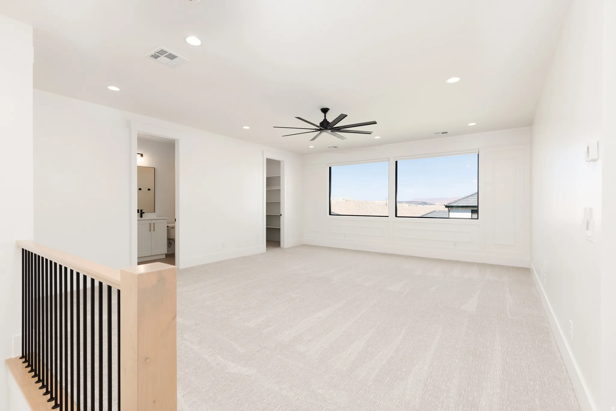 Spacious loft area featuring expansive windows, recessed lighting, and a contemporary ceiling fan