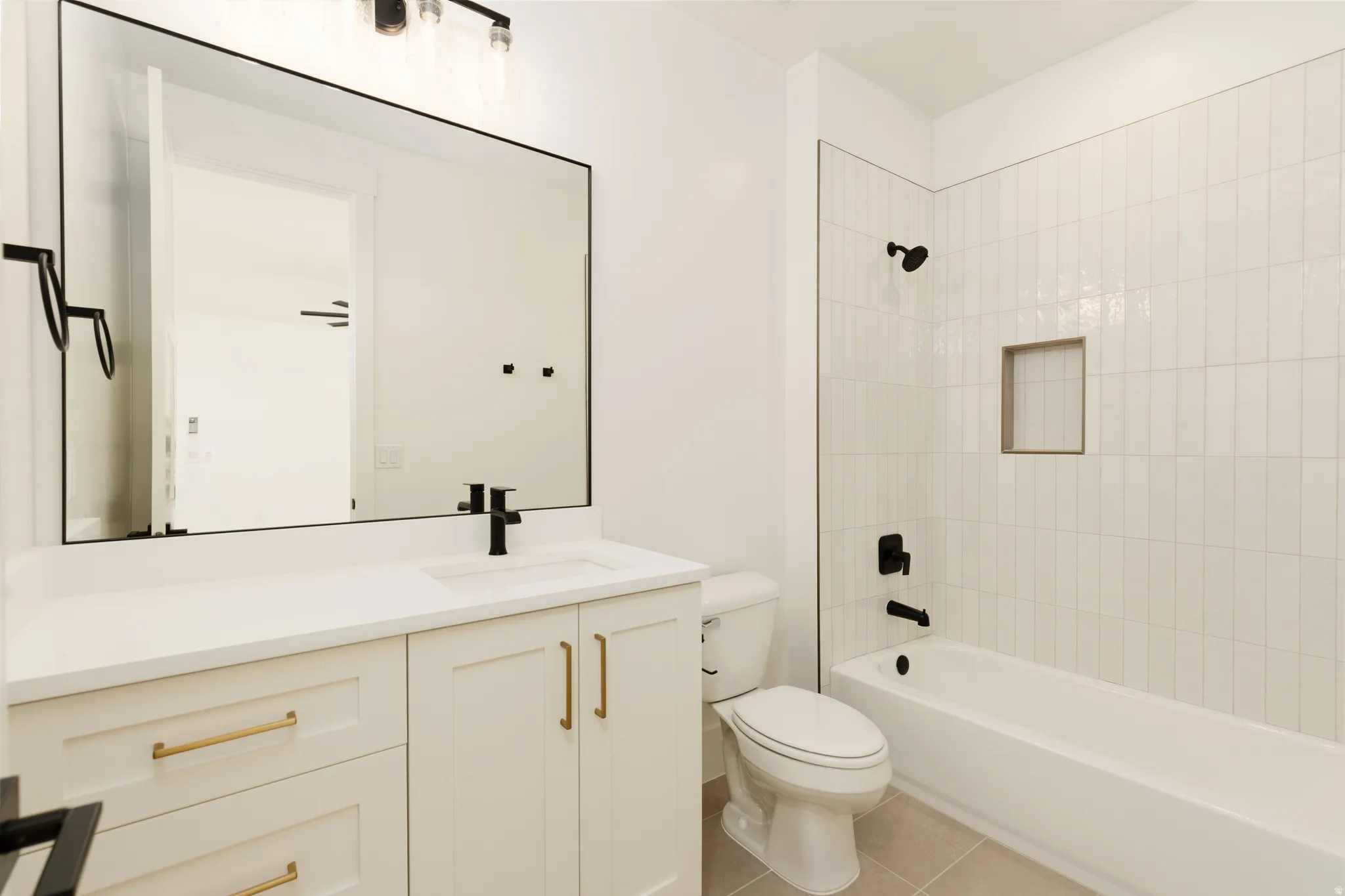 Bathroom featuring a white vanity with gold-tone hardware, rectangular sink, and black faucet