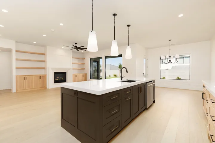 Kitchen island with solid surface countertop, integrated sink, and pendant lighting