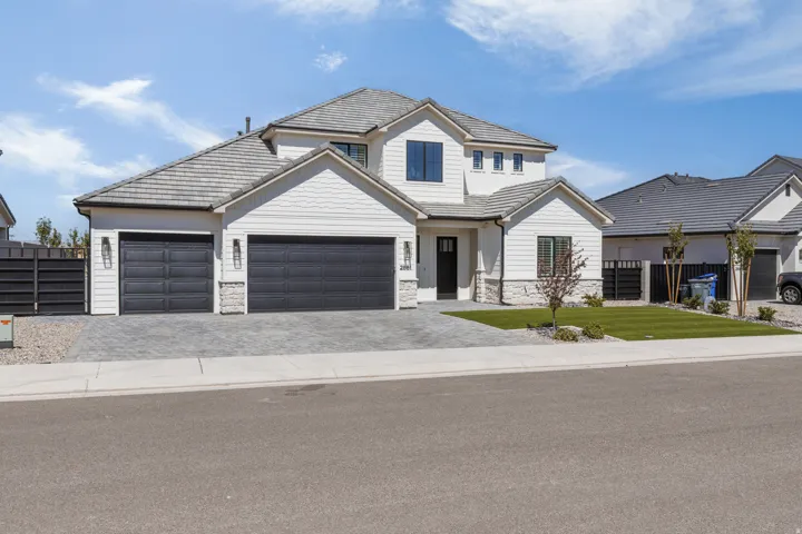 Contemporary exterior featuring white siding, a multi-gabled roof, and stone accents