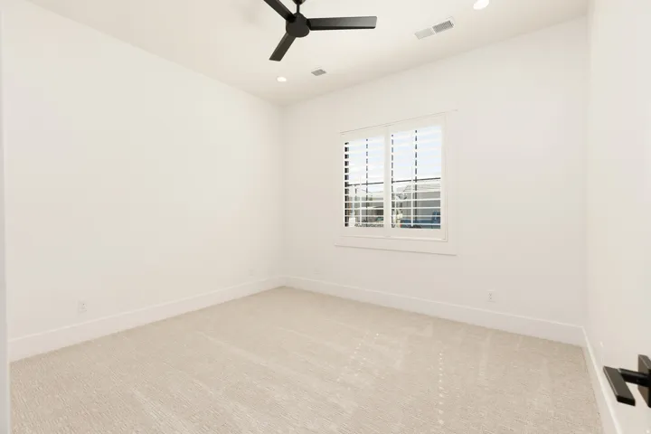 Recessed lighting, black ceiling fan, plantation shutters, light-toned carpeting, and white walls