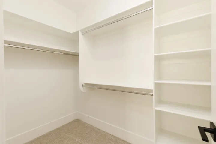 Built-in closet system featuring multiple hanging rods and integrated shelving