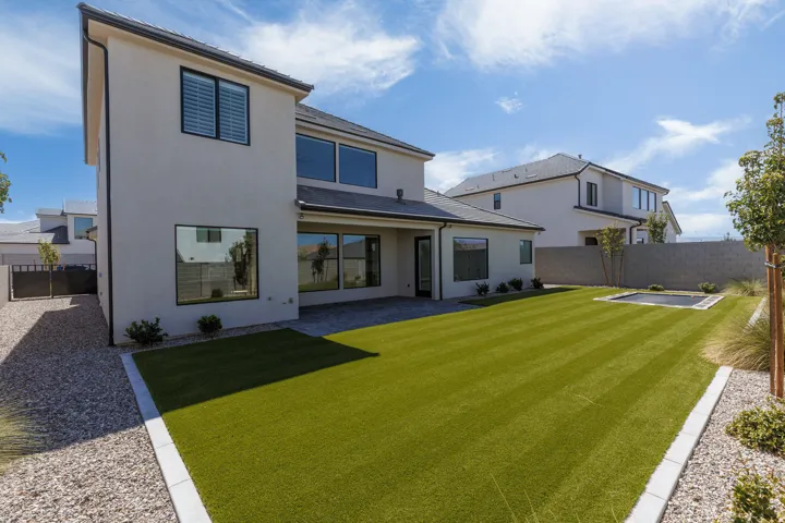 Expansive rear yard featuring artificial turf, a built-in trampoline, and a gravel border