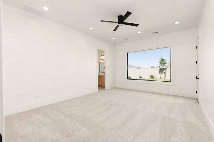 Recessed lighting, ceiling fan with matte black finish, large window, shiplap accent wall, and light-toned carpeting