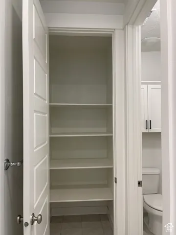 Built-in shelving with multiple levels, paneled interior doors, and tile flooring