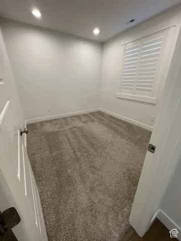 Plush carpet flooring, recessed ceiling lighting, plantation shutters, and crisp white trim