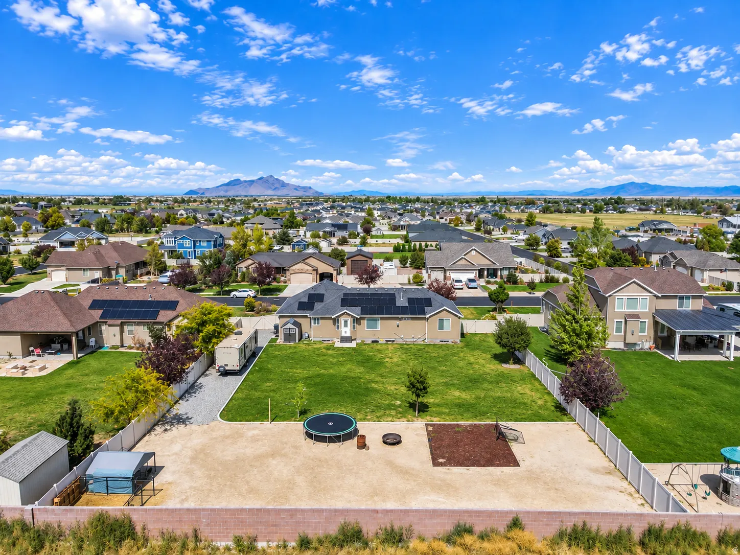 Expansive backyard with a manicured lawn, gravel area, and privacy fencing
