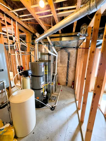 Utility area featuring exposed wood framing, water heater, water softener and furnace