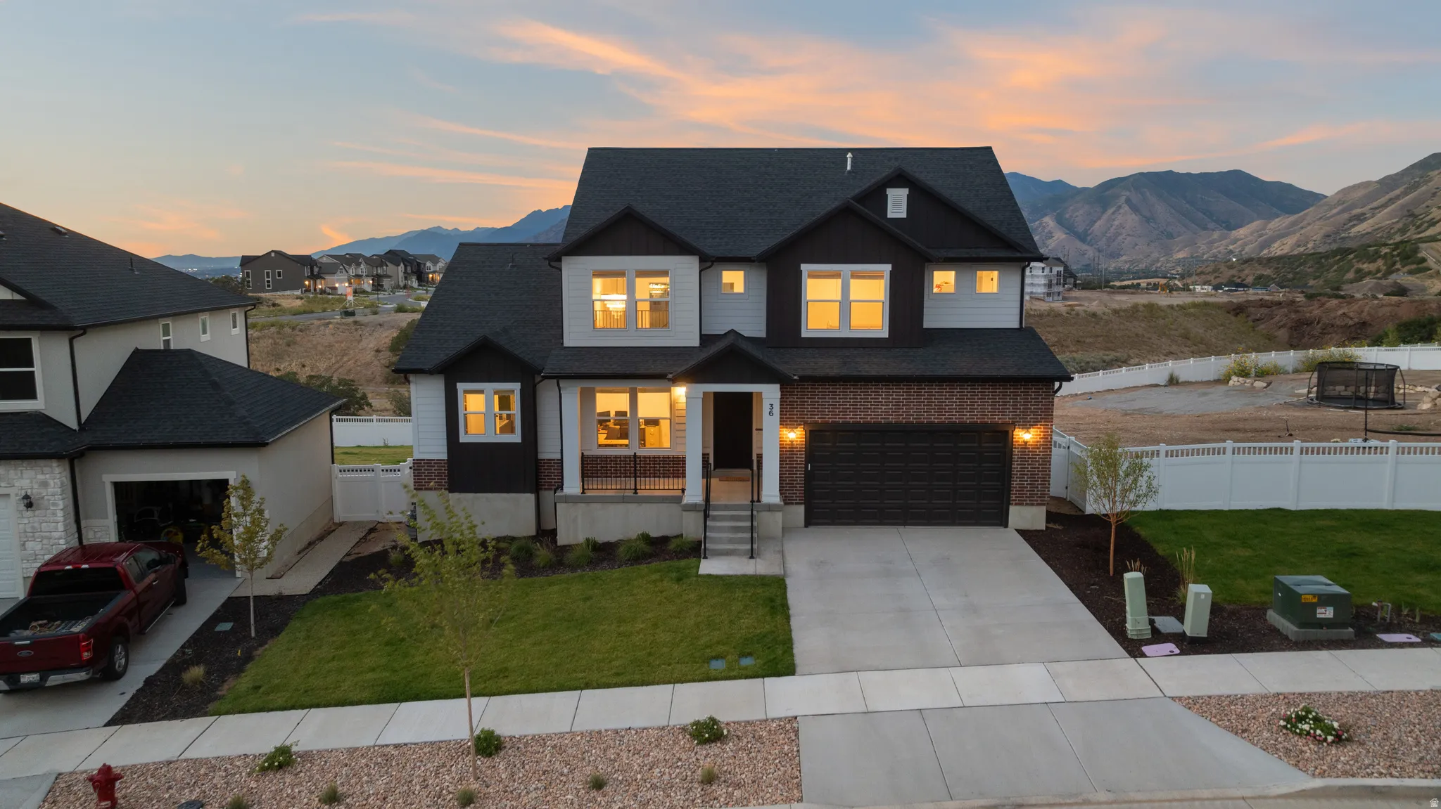 Modern two-story residence with a multi-textured facade, attached two-car garage, and a concrete driveway
