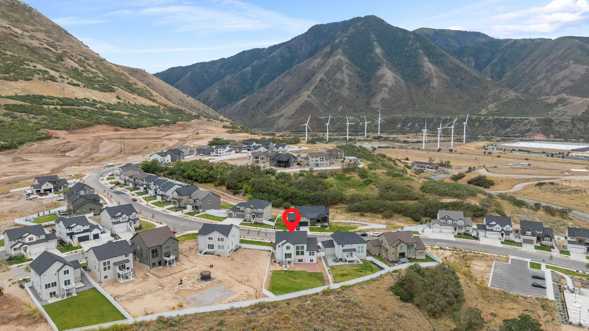 Residential development with mountain backdrop, established roadways, and multiple homes featuring diverse exterior finishes