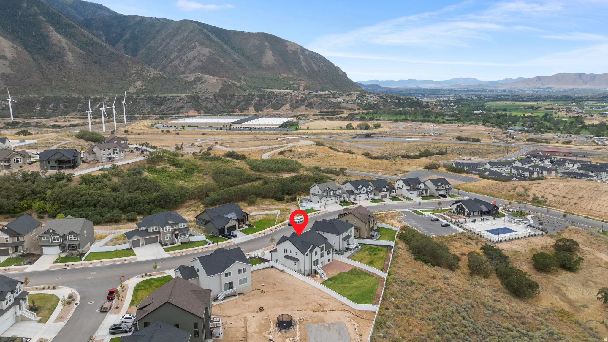 Mountain backdrop, wind turbines, residential community, multiple homes, community pool