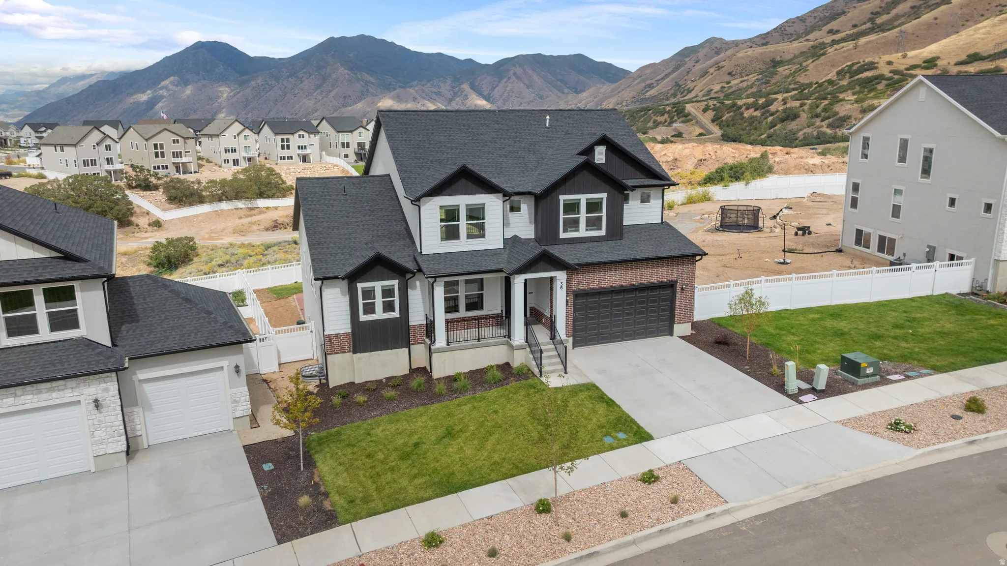 Modern two-story residence with a dark shingle roof and a two-car garage
