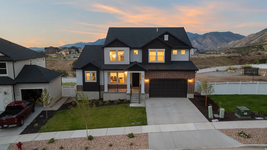 Modern two-story residence with a multi-textured facade, attached two-car garage, and a concrete driveway