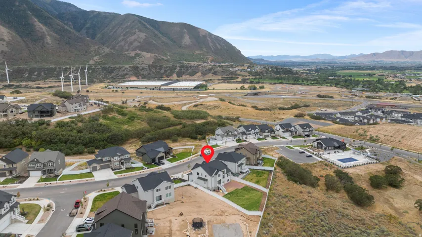 Mountain backdrop, wind turbines, residential community, multiple homes, community pool