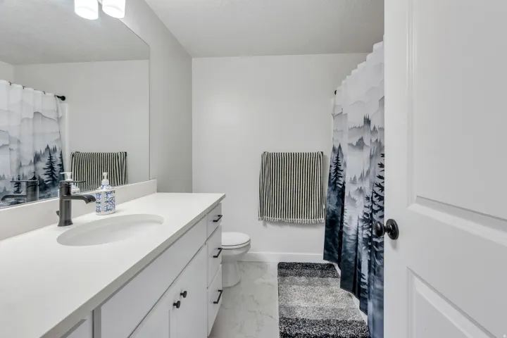 White vanity with undermount sink and dark-finish faucet