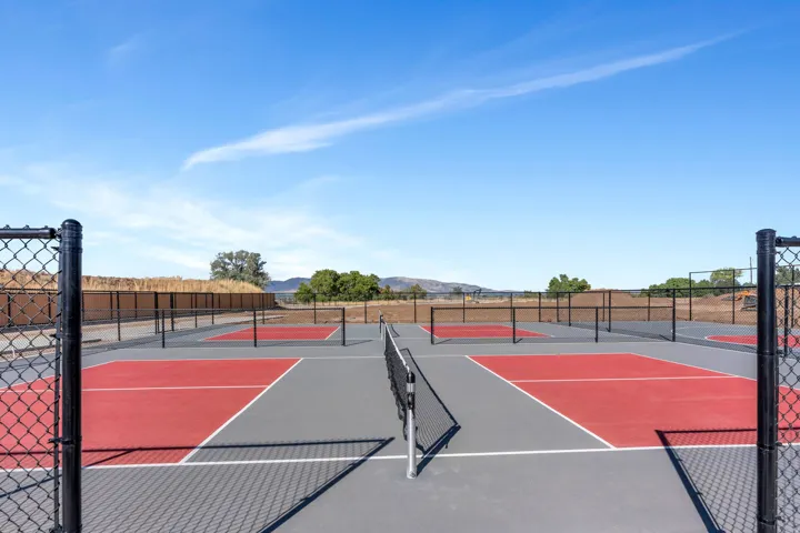 Multiple dedicated pickleball courts with chain-link fencing and painted surfaces