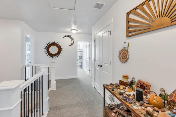 Hallway featuring light gray carpet flooring, white walls, white trim, and two white solid core doors