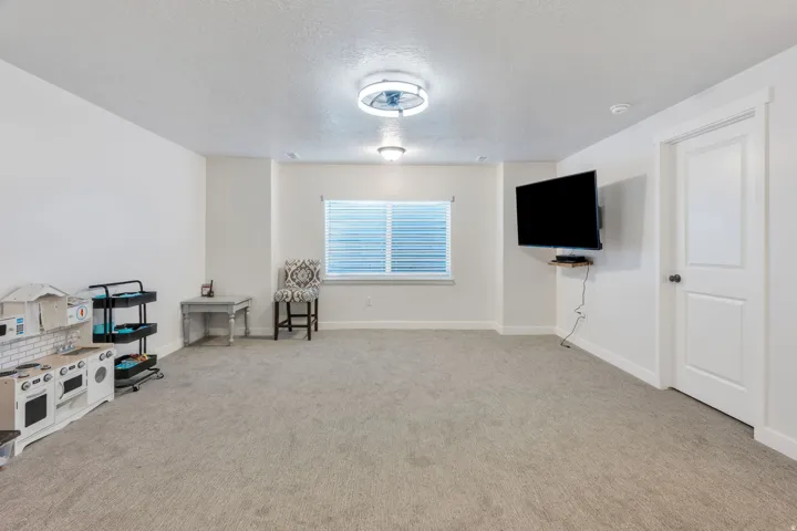 Carpeted room featuring a window with blinds, a ceiling-mounted fan with light, and recessed lighting