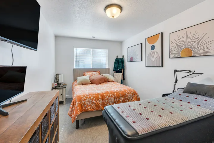 Recessed window with blinds, ceiling-mounted light fixture, light gray carpet flooring, and white painted walls