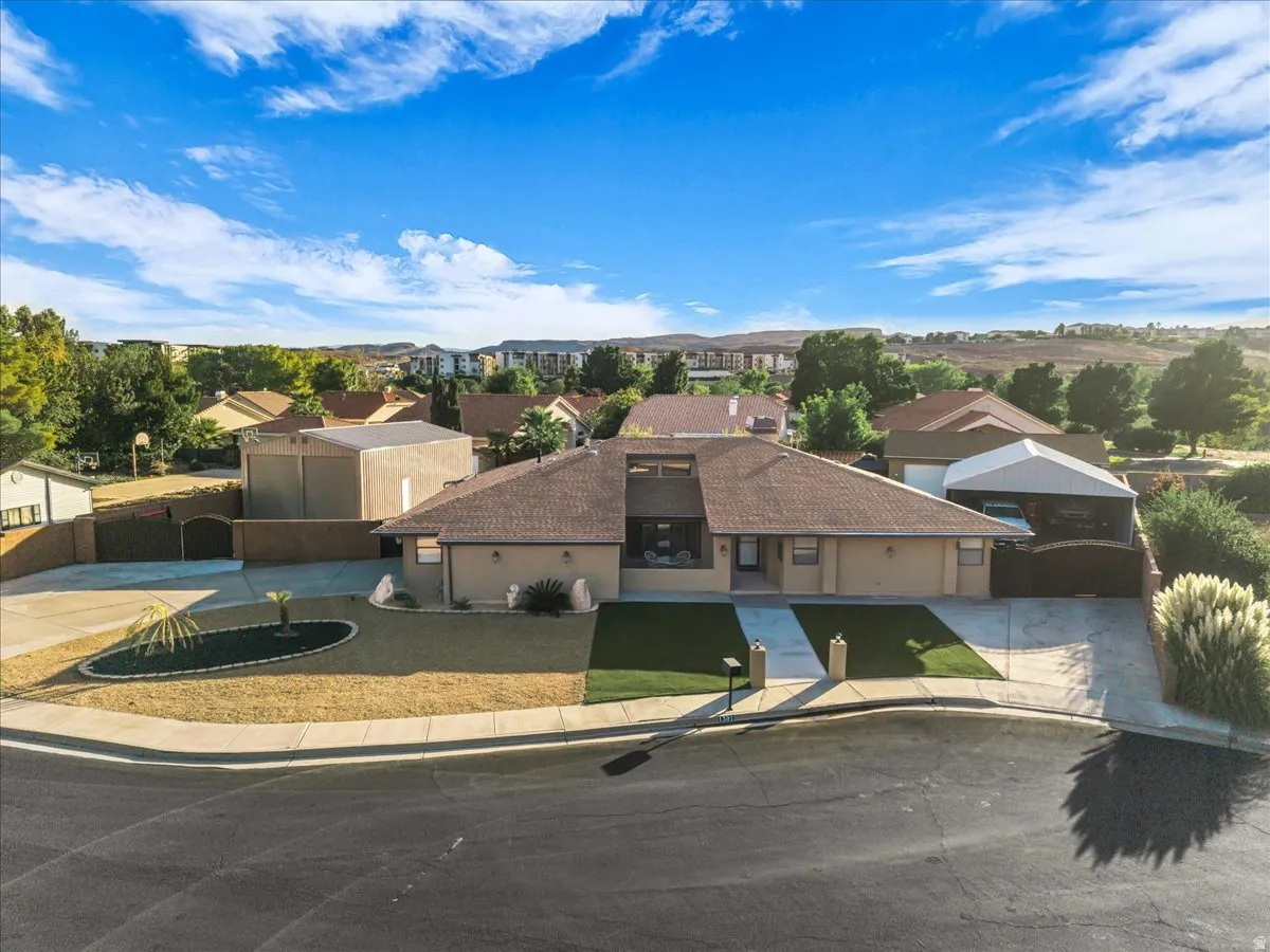 Single-story residence with a paved driveway, attached two-car garage, and a covered carport
