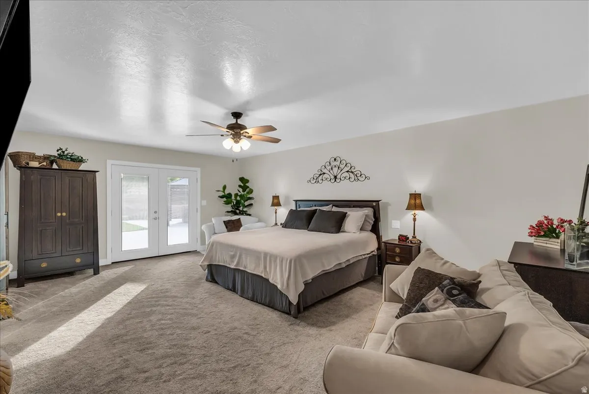 Spacious room with light-colored walls, ceiling fan with integrated lighting, and light-toned carpet flooring