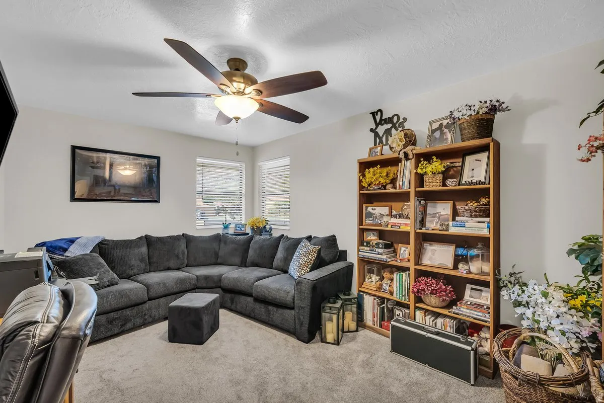 Recessed lighting, ceiling fan with integrated lighting, multiple windows with blinds, and built-in shelving units