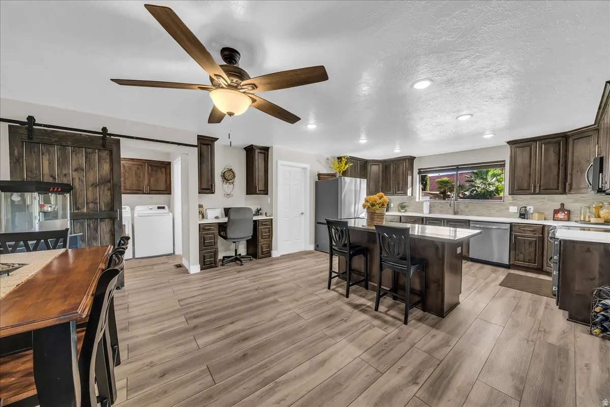 Wood-finish flooring, recessed lighting, and a ceiling fan with integrated light