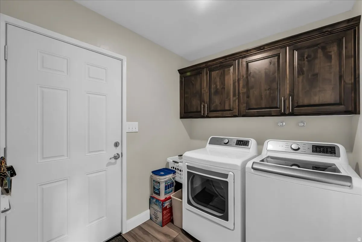 Dark wood-finish cabinetry, light neutral wall paint, and wood-finish flooring