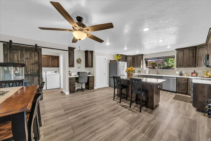 Wood-finish flooring, recessed lighting, and a ceiling fan with integrated light