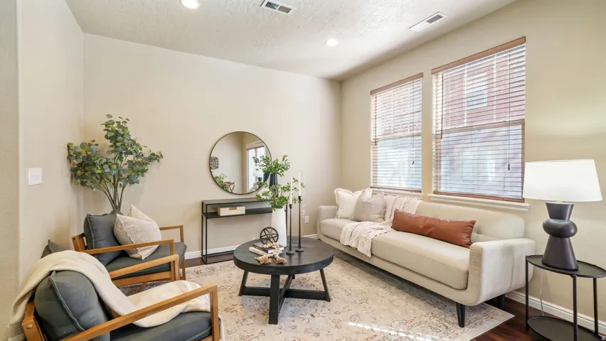 Recessed lighting illuminates the living area with wood-finish flooring