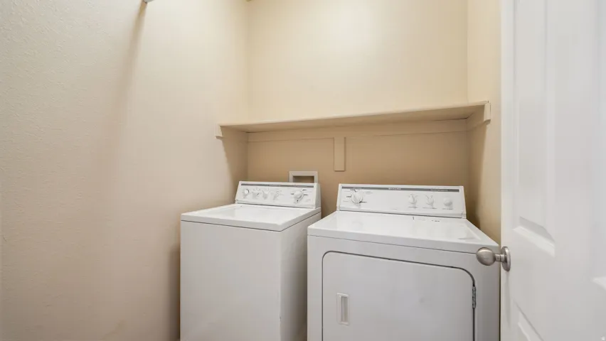Dedicated laundry space featuring a built-in shelf and neutral wall tones