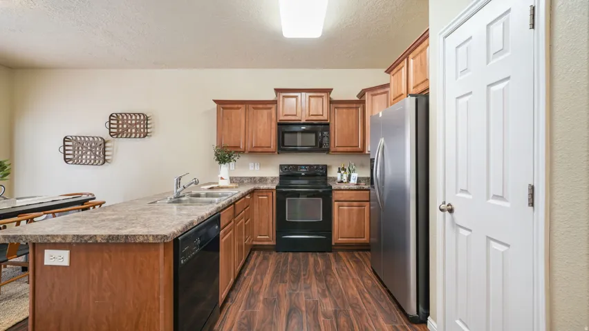 Kitchen featuring wood-finish flooring, wood cabinetry, a breakfast bar, and stainless steel appliances