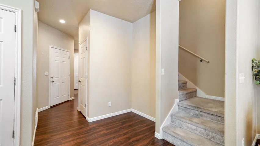 Wood-finish flooring, recessed lighting, and a staircase with carpeted treads