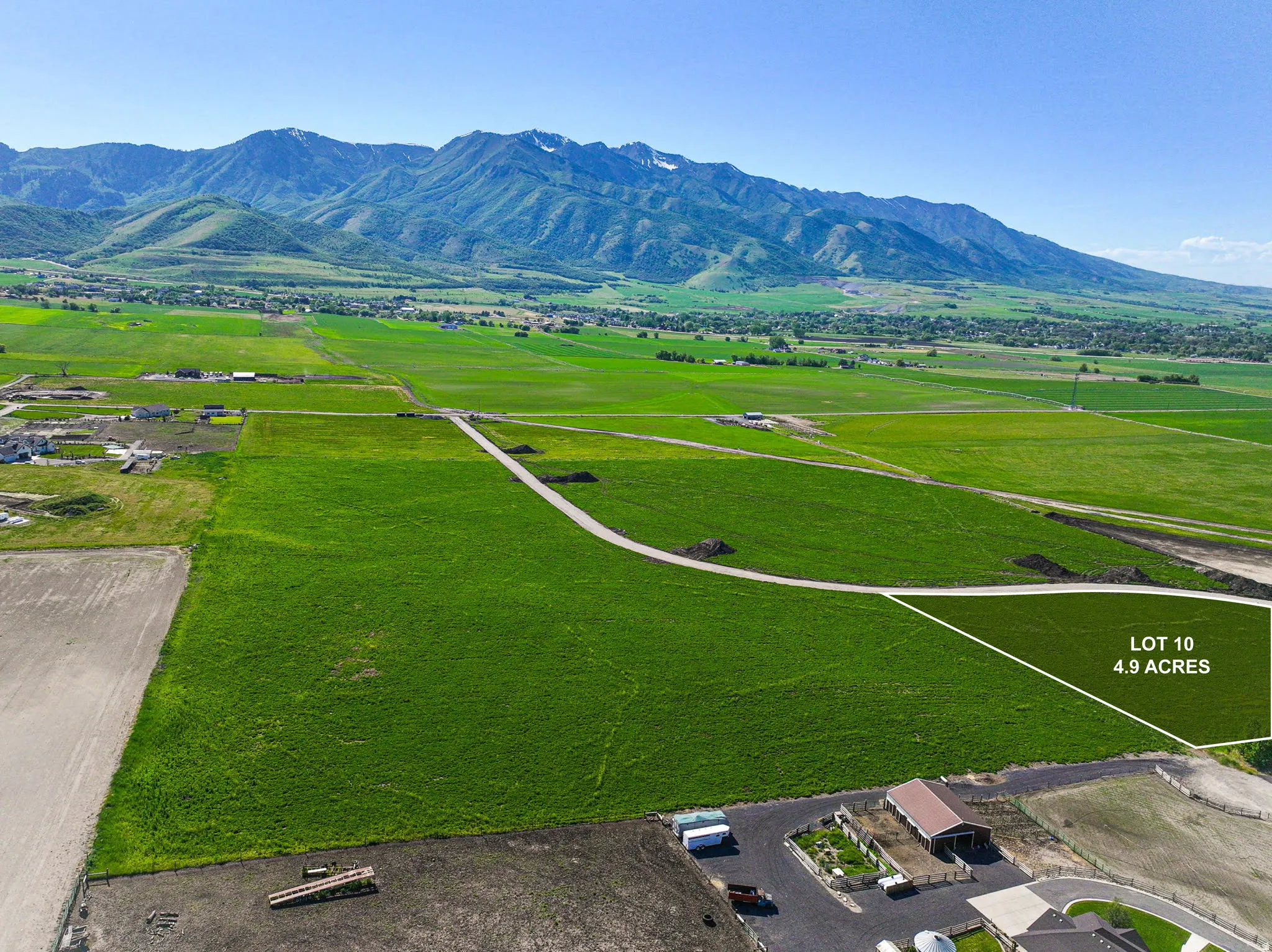 4.9-acre lot featuring lush green fields and direct mountain backdrop