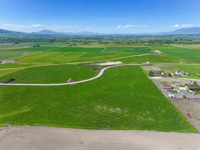 Expansive green lot with a gravel path and distant mountain scenery