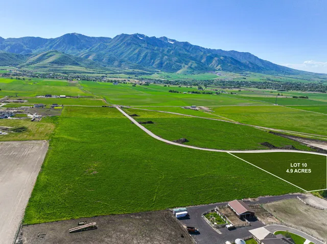 4.9-acre lot featuring lush green fields and direct mountain backdrop