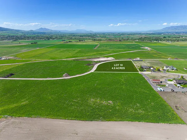 Expansive 4.9-acre lot with clear boundaries, surrounded by green fields