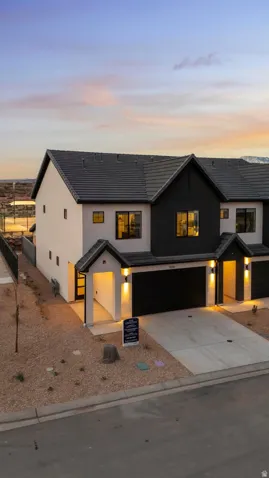 Modern architectural design featuring distinct black and white facade, integrated garage, and a covered entry