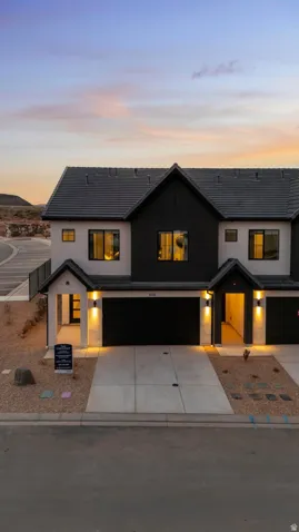 Modern exterior design with a black shingle roof, dark-framed windows, and integrated garage