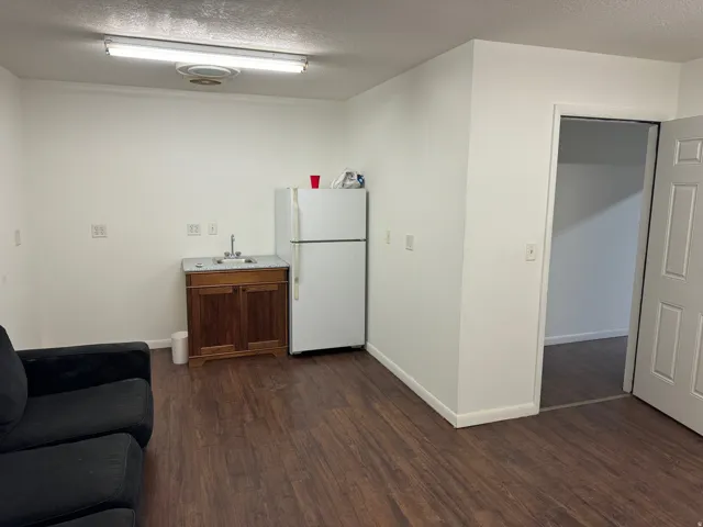 Wood-finish flooring, white walls, and a built-in sink with cabinetry
