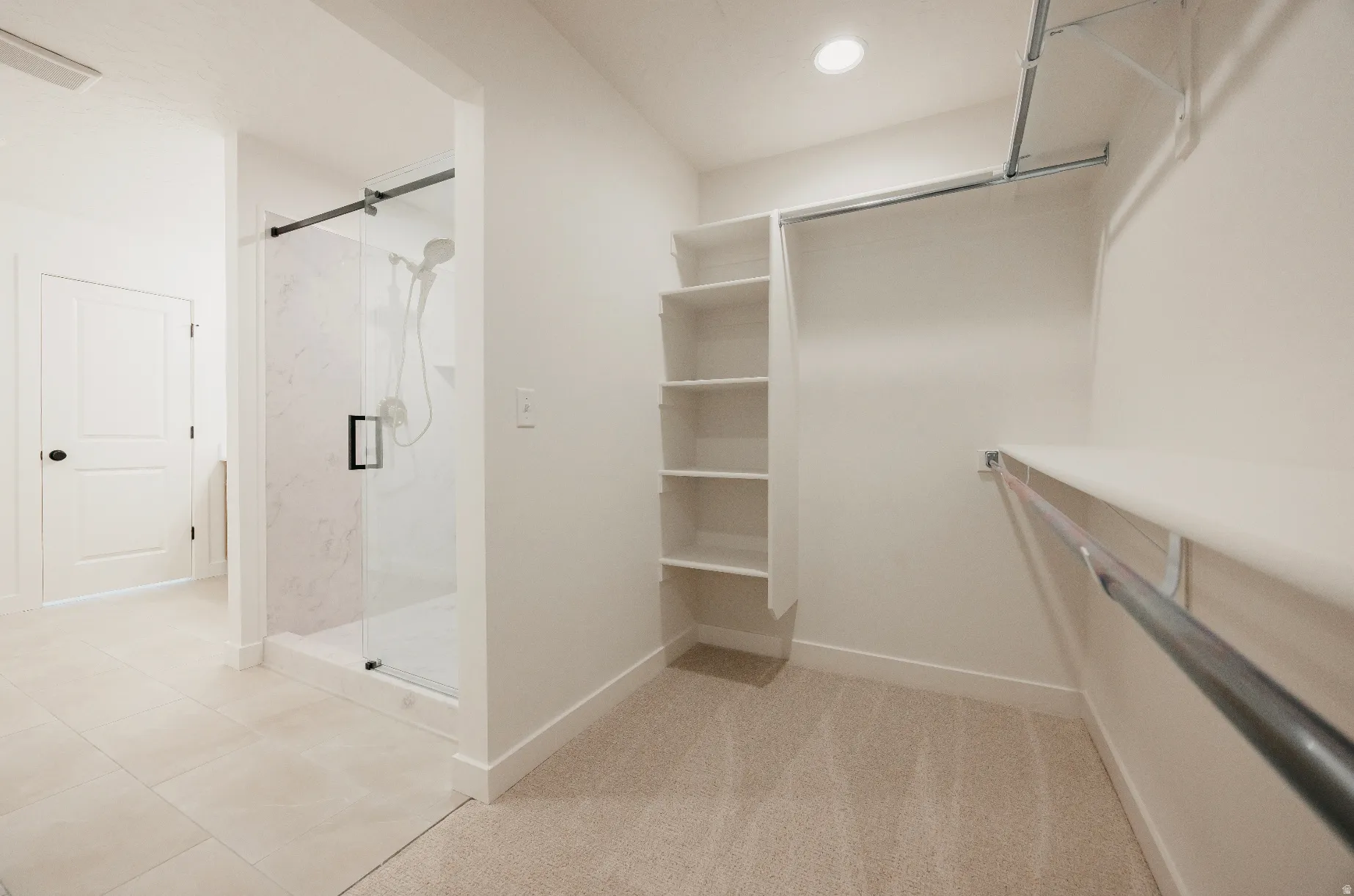 Walk-in closet featuring built-in shelving, hanging rods, and carpet flooring