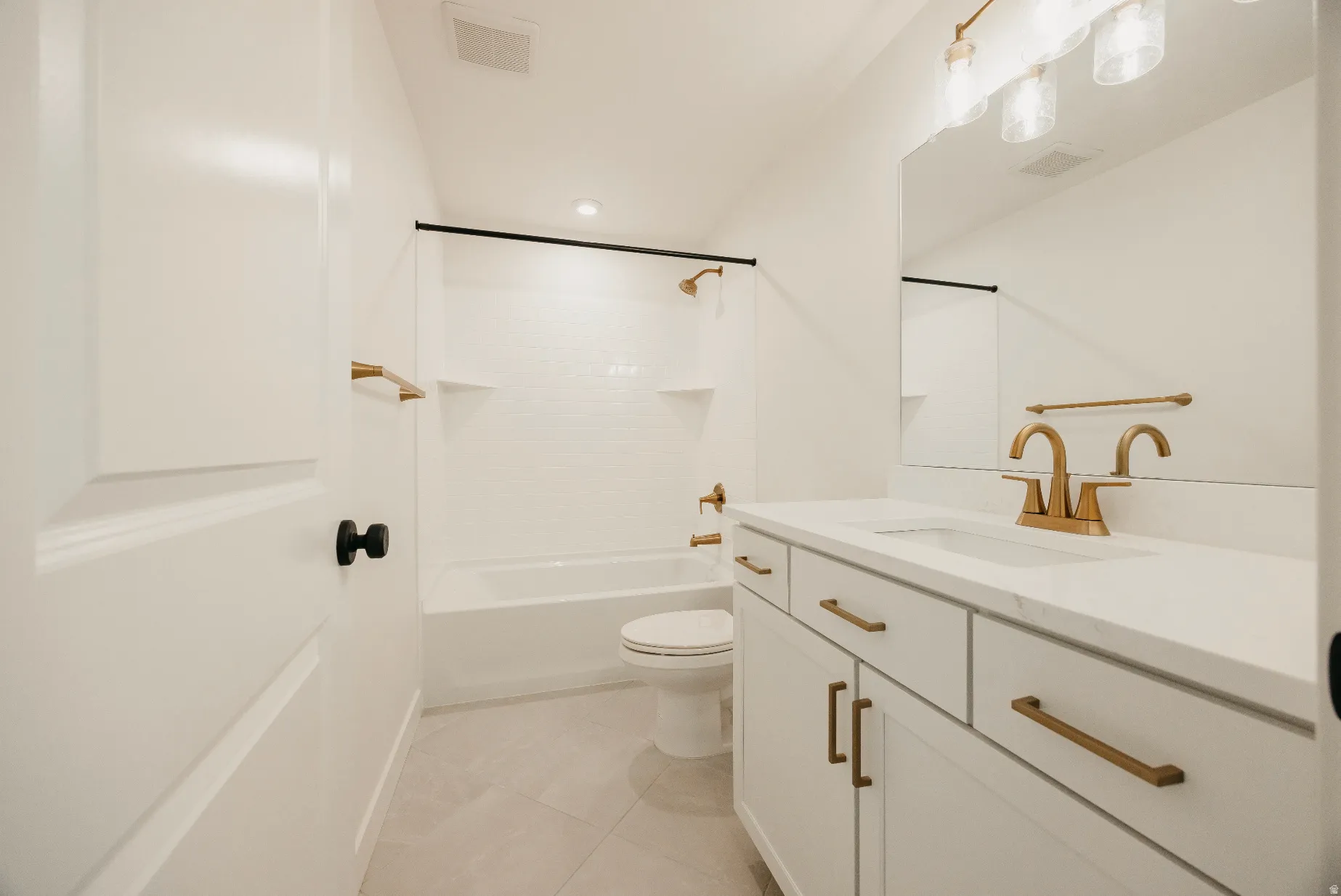 White vanity with gold-finish hardware, built-in rectangular sink, and gold-finish faucet