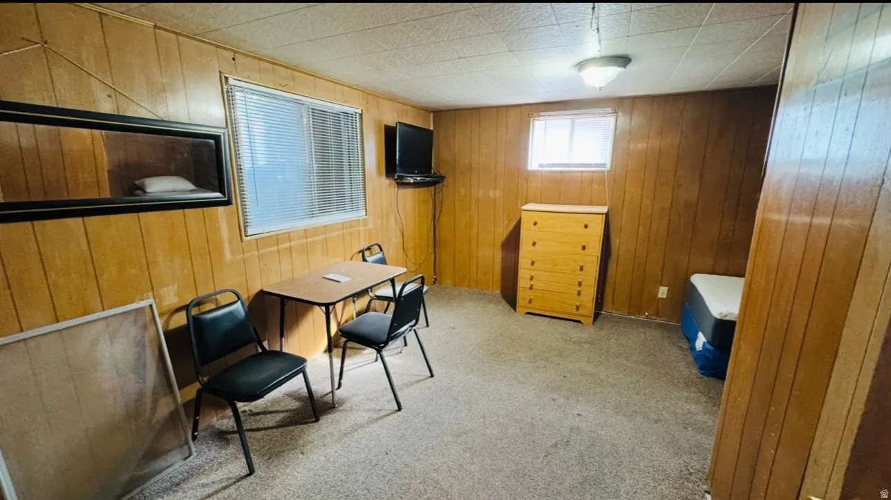 Wood paneling throughout, featuring two windows with blinds, and a built-in ceiling light fixture