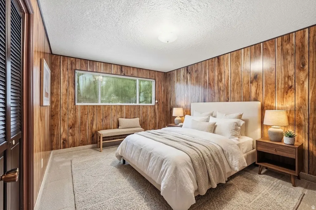 Wood paneling, flush mount ceiling light, louvered closet doors, and broad window