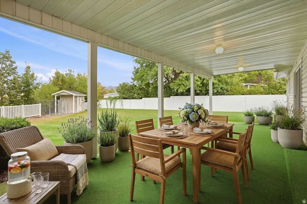 Covered patio with a paneled ceiling, integrated lighting, and artificial turf flooring