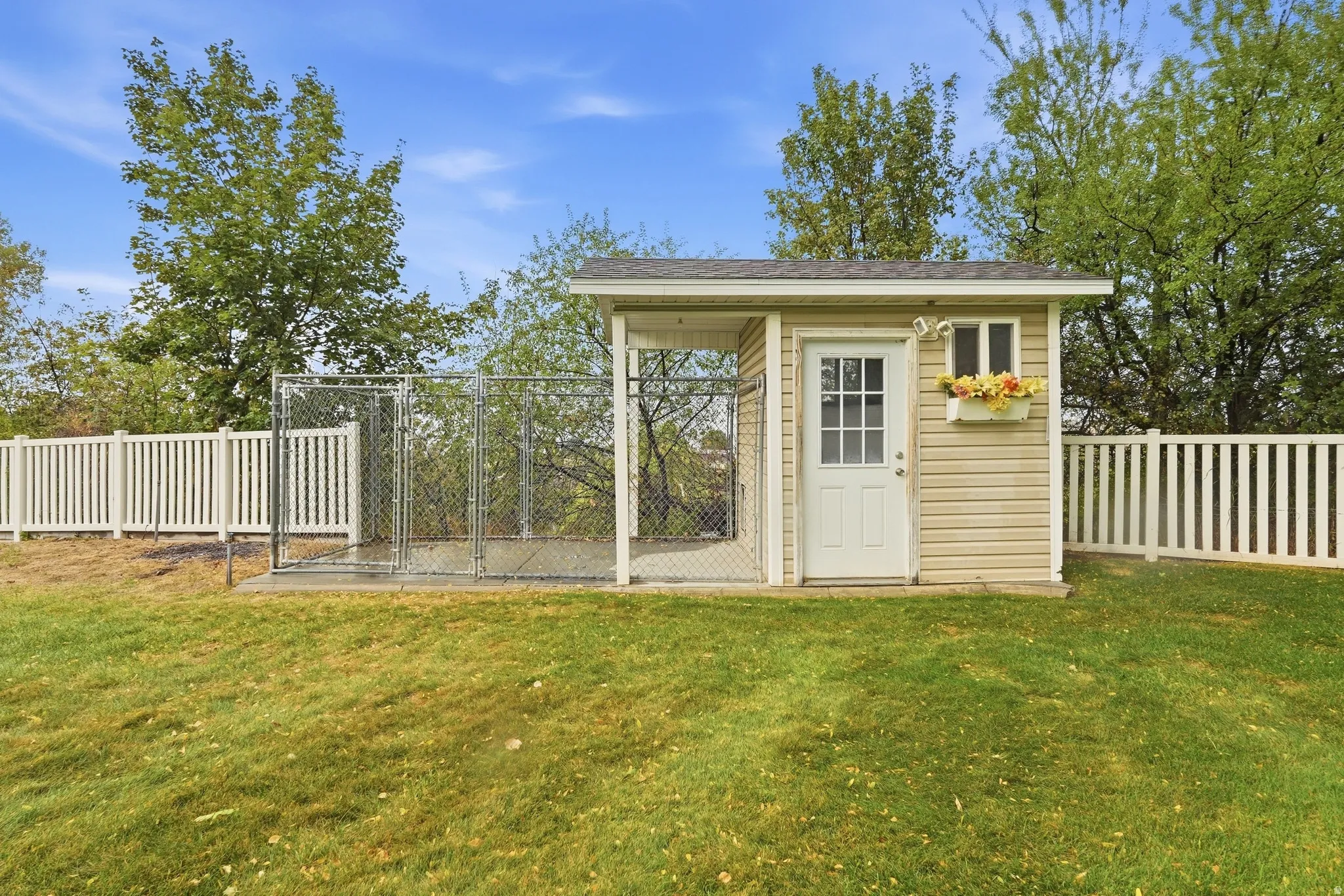 Outdoor shed with siding exterior, white trim, and a window box