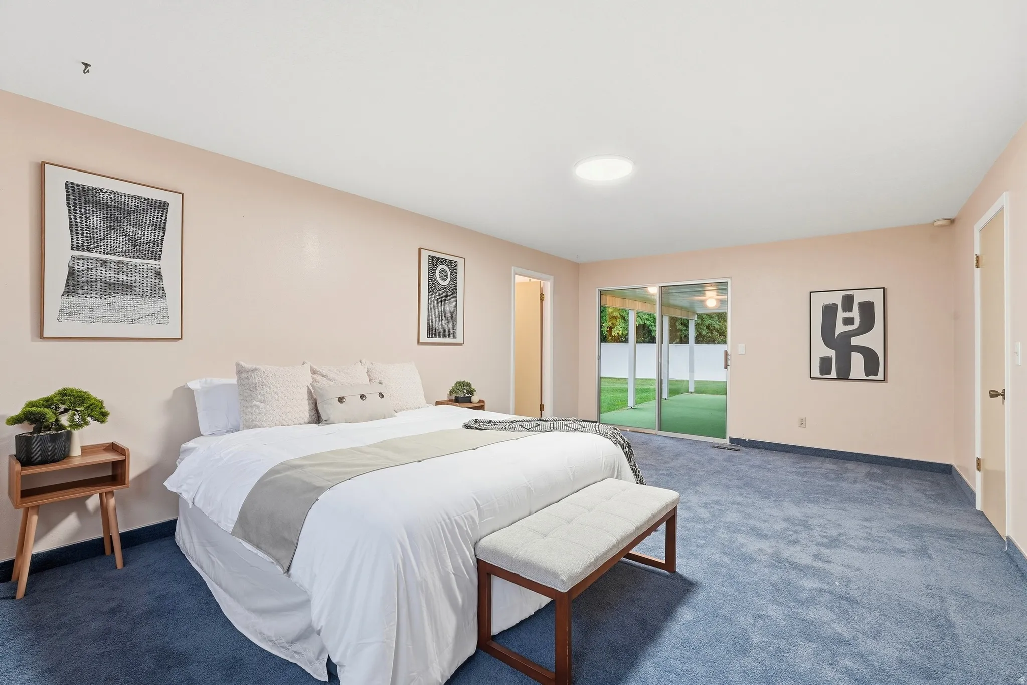Sliding glass doors opening to the exterior, recessed ceiling light, and blue carpeting