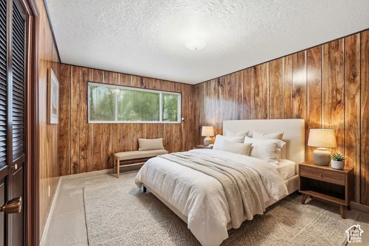 Wood paneling, flush mount ceiling light, louvered closet doors, and broad window