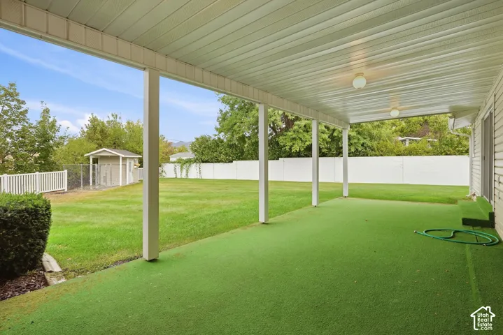 Covered patio with artificial turf surfacing, supported by white posts