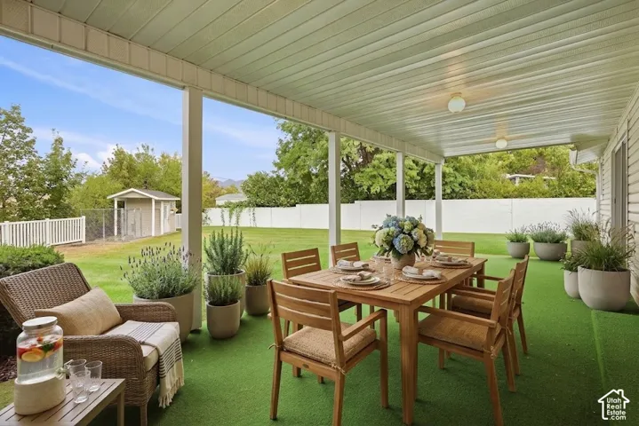 Covered patio with a paneled ceiling, integrated lighting, and artificial turf flooring